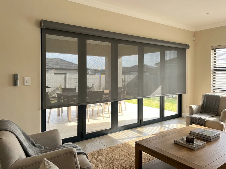 Motorised roller blind with wall remote extended over a stacker door in a Brackenfell lounge